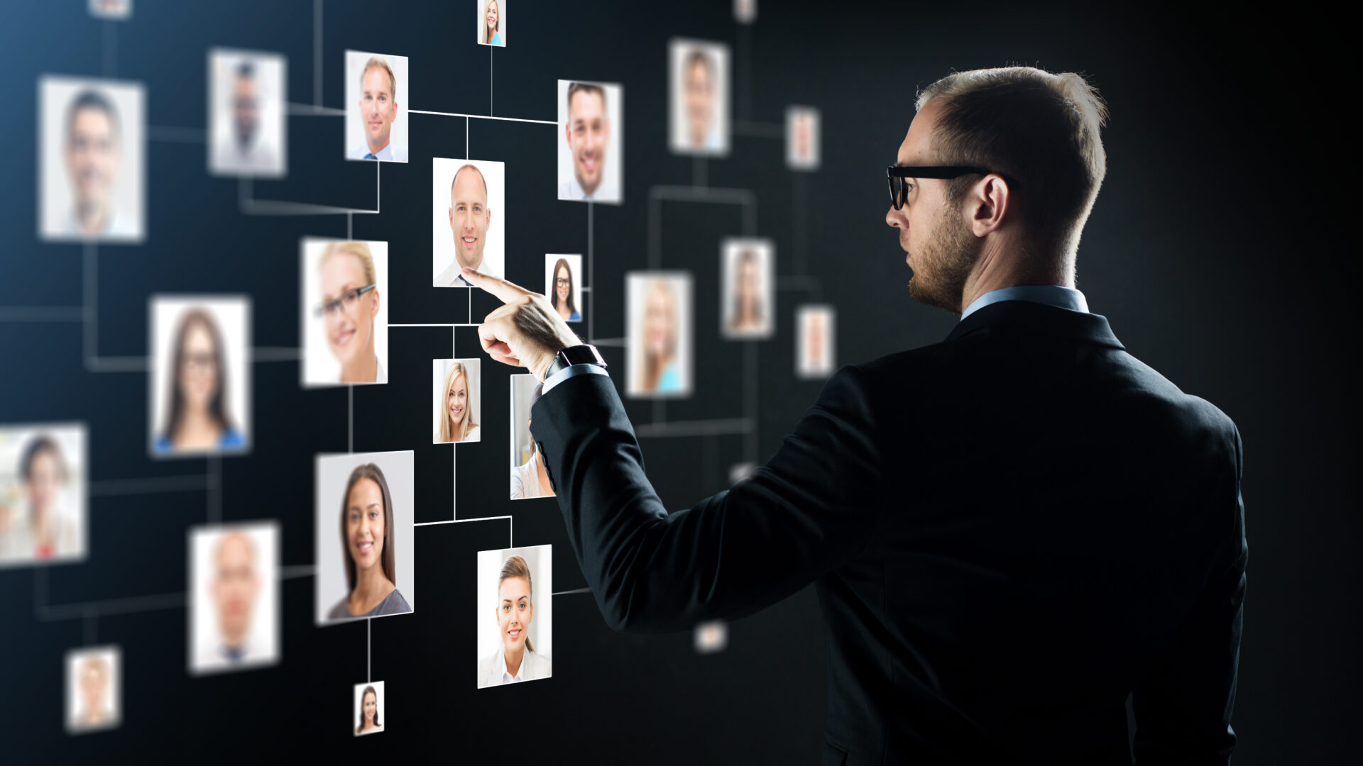 Ein Mann schaut sich verschiedene Fotos von Menschen an, die auf einer Leine aufgehängt sind