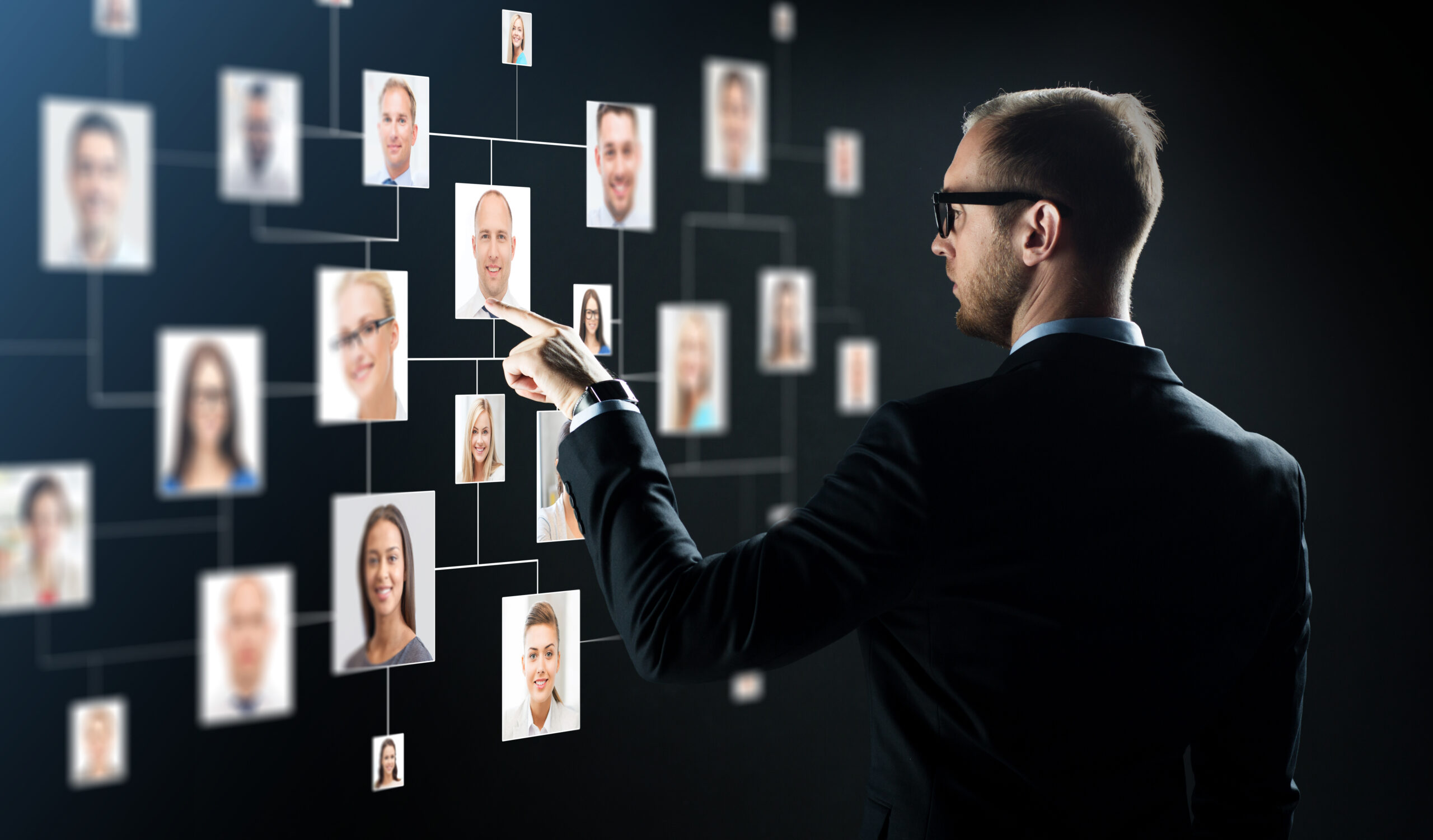 Ein Mann schaut sich verschiedene Fotos von Menschen an, die auf einer Leine aufgehängt sind